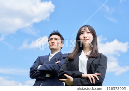 Men and women in suits looking up at the sky with dignified expressions Men and women in suits looking up at the sky with dignified expressions 116572905