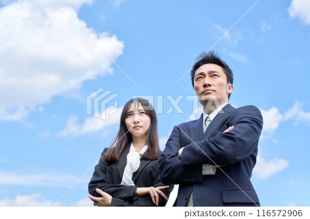 Men and women in suits looking up at the sky with dignified expressions Men and women in suits looking up at the sky with dignified expressions 116572906