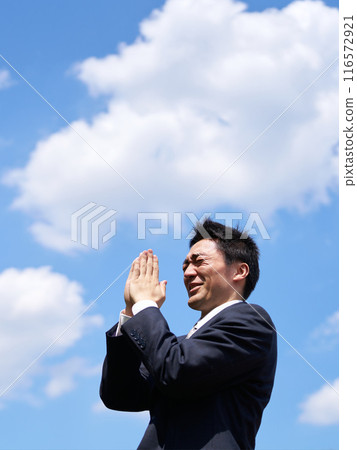 藍天下雙手合十祈禱的男人 116572921