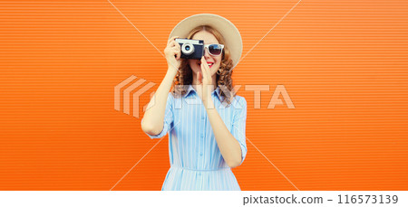 Portrait of happy young woman photographer with film camera, modern girl taking a picture in summer 116573139