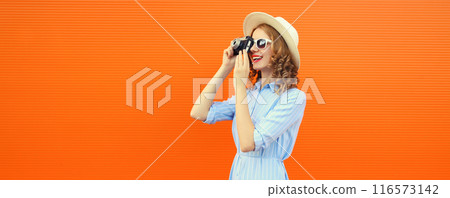 Portrait of happy young woman photographer with film camera, modern girl taking a picture in summer 116573142
