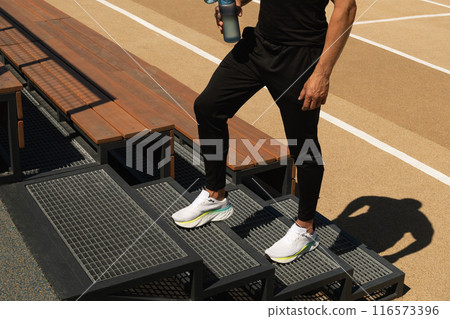 Athletes man legs on stair. sports ground. Outdoor workout. Copy space. Athletes man legs on stair. sports ground. Outdoor workout. Copy space. 116573396