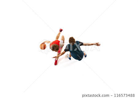 Player in red dribbling, while opponent in blue attempts to block him from ground against white studio background. Aerial view. 116573488
