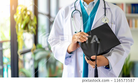 Doctor holding graduation gap hat, education medicine. Doctor holding graduation gap hat, education medicine. 116573587