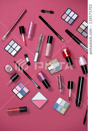 Various decorative cosmetics and brushes on a pink background, top view. Various decorative cosmetics and brushes on a pink background, top view. 116573703