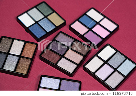 A set of multi-colored eyeshadow on a pink background. Eye makeup 116573713