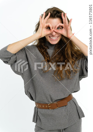 Woman making binoculars from hands isolated on white background. 116573801