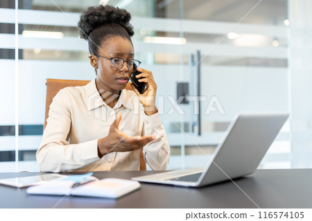 Businesswoman multitasking with phone and laptop modern office setting. Professional woman engaged in conversation while handling business tasks. Concept communication, technology, and productivity. Businesswoman multitasking with phone and laptop modern office setting. Professional woman engaged in conversation while handling business tasks. Concept communication, technology, and productivity. 116574105