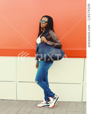 Fashionable young African woman with handbag in casual, stylish black girl posing in the city 116574209