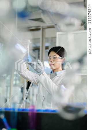 Young woman in lab coat and eyeglasses 116574244