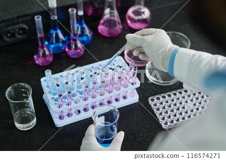 Gloved scientist making experiment Gloved scientist making experiment 116574271