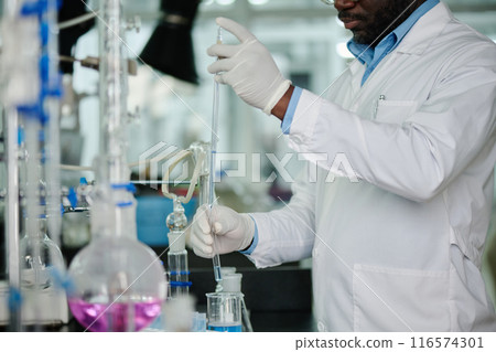 Man using glassware during experiment Man using glassware during experiment 116574301