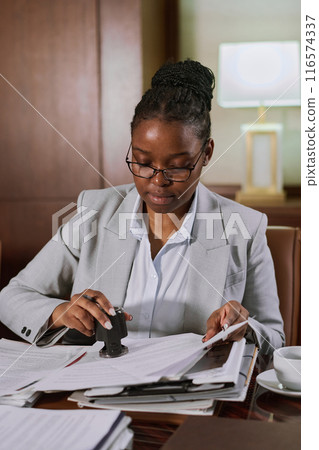 Putting stamp on paper documents 116574337