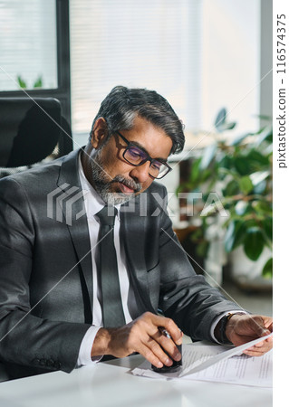 Stamping signed paper documents by desk 116574375