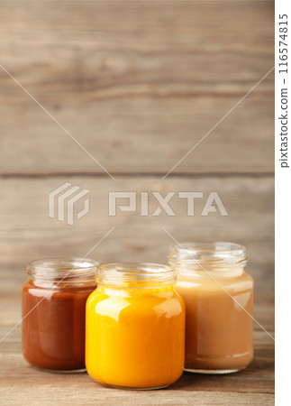 Jars of baby puree on grey wooden background 116574815