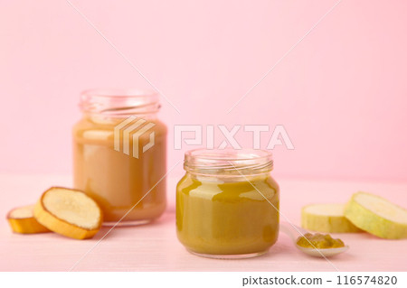 Glass jars with nutrient baby food on pink background Glass jars with nutrient baby food on pink background 116574820
