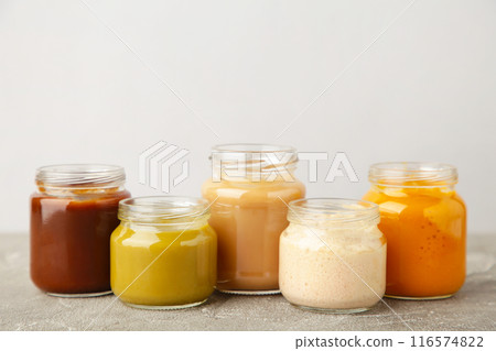 Jars of baby puree on grey background Jars of baby puree on grey background 116574822