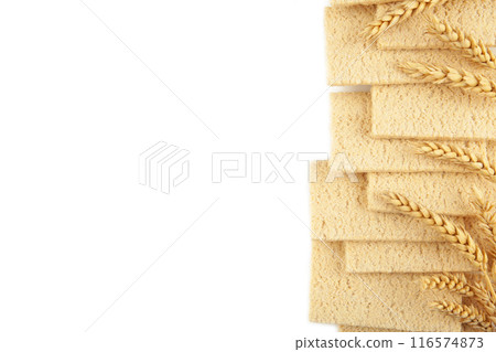 A slices of wheat crispbread with spikelets of wheat isolated on white background. A slices of wheat crispbread with spikelets of wheat isolated on white background. 116574873