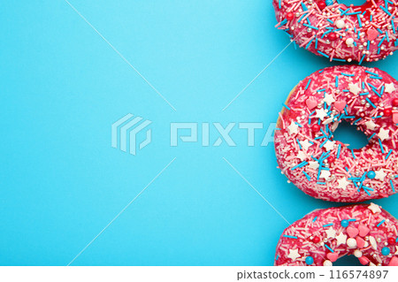 Donuts with icing on pastel blue background. Sweet donuts. Donuts with icing on pastel blue background. Sweet donuts. 116574897