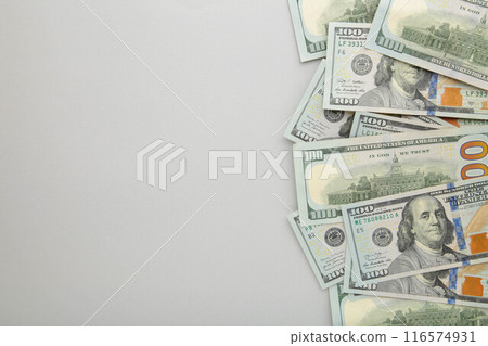 A pile of hundred dollar bills on grey background with copy space A pile of hundred dollar bills on grey background with copy space 116574931