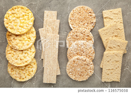 Various types of healthy whole grain crispbreads on grey concrete background. 116575038