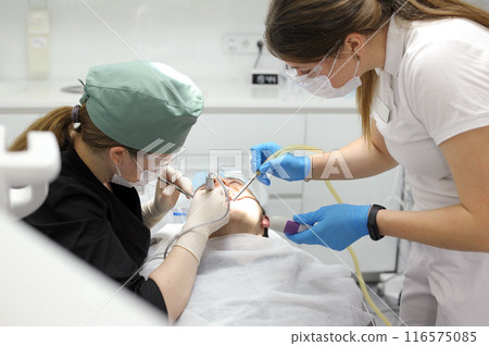 Attractive young woman in stomatology clinic with female dentist. Healthy teeth concept. Attractive young woman in stomatology clinic with female dentist. Healthy teeth concept. 116575085