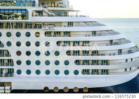 Large cruise ship side view fragment with round portholes rows and cabins balconies with railing Large cruise ship side view fragment with round portholes rows and cabins balconies with railing 116575230