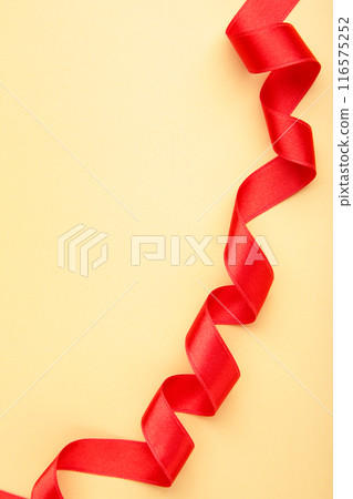 Shiny red ribbon on beige background with copy space. 116575252