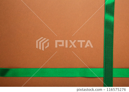 Green ribbon on brown background with clipping path. 116575276