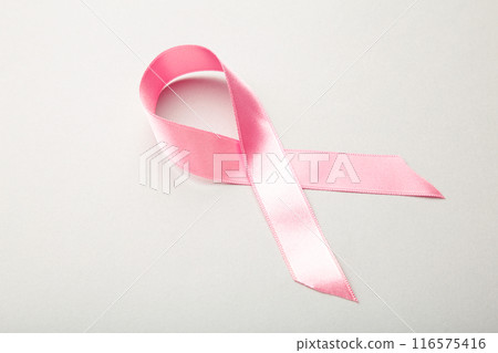 Pink satin breast cancer awareness ribbon on grey 116575416