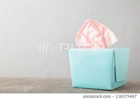 Blue box with paper tissues on grey background with copy space 116575487