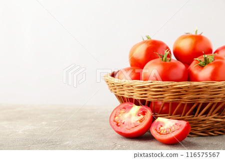 Ripe red tomatoes in basket on grey background. 116575567