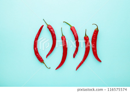 Red hot chili peppers on blue background Red hot chili peppers on blue background 116575574