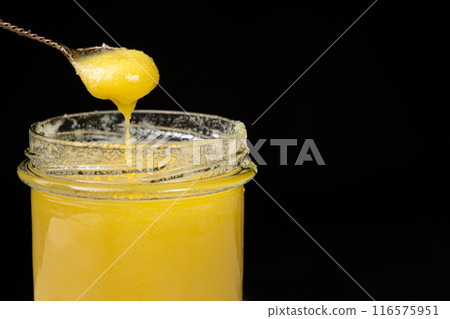 Natural ghee healthy lactose-free oil for frying, black background, copy space for text Natural ghee healthy lactose-free oil for frying, black background, copy space for text 116575951