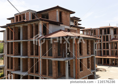 Cottage, Building Under Construction, Made Of Red Hollow Clay Bricks, Tile Roof, Balcony. Blue Sky And Green Tree On Background. Village, Town house. Horizontal Plane. Real Estate. 116576286