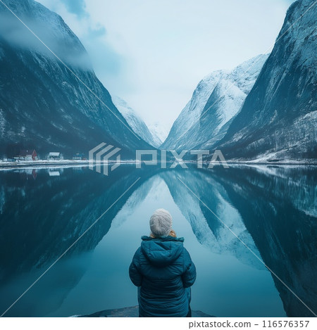 Elderly woman sitting winter coat lake snow-covered mountains Norway winter Elderly woman sitting winter coat lake snow-covered mountains Norway winter 116576357