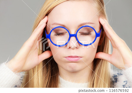 Nerdy woman in big holding head 116576592