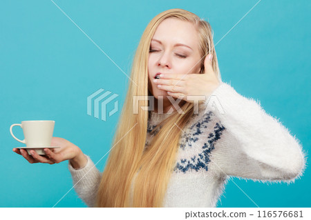 Sleepy woman holding cup of coffee 116576681