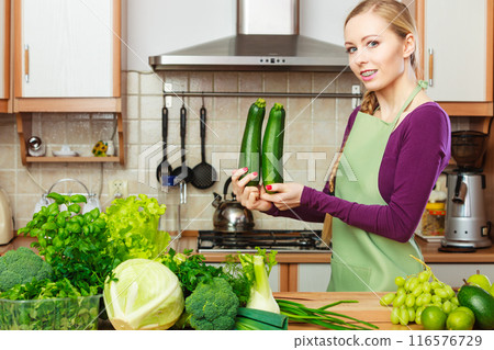 Woman housewife in kitchen with green vegetables Woman housewife in kitchen with green vegetables 116576729