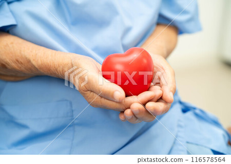Asian doctor give red heart to elderly woman in her hand, heart Attack. Asian doctor give red heart to elderly woman in her hand, heart Attack. 116578564