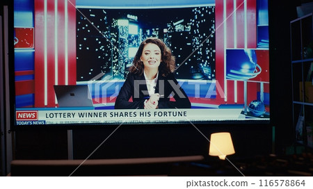 Close up shot of breaking news presented by anchorwoman, displayed on modern ultrawide TV in empty dark living room. Newscast on VOD channel about artificial intelligence reportage Close up shot of breaking news presented by anchorwoman, displayed on modern ultrawide TV in empty dark living room. Newscast on VOD channel about artificial intelligence reportage 116578864