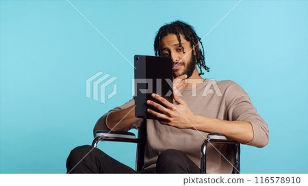 Artist in wheelchair holding tablet, using tactile touchscreen to draw. Person with disability doing digital art on drawing portable device, enjoying hobby in studio background, camera A Artist in wheelchair holding tablet, using tactile touchscreen to draw. Person with disability doing digital art on drawing portable device, enjoying hobby in studio background, camera A 116578910