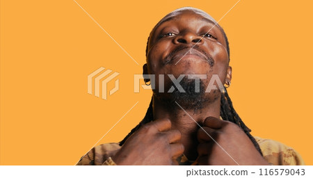POV of african american guy looks at his reflection in the mirror, arranging his beard and dreads to be confident and trendy. Modern adult is looking at himself and feeling good. Tripod shot. 116579043