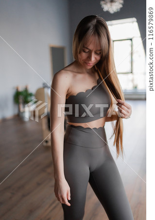 Pilates fitness trainer in pilates studio. Young sporty attractive woman wearing sportswear in yoga studio. Fit, healthy and strong authentical body. Fitness concept 116579869