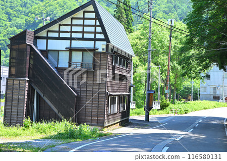 Snow country houses standing on a street near Oshima Bridge on the Kiyotsu River, Yuzawa Town, Niigata Prefecture 116580131