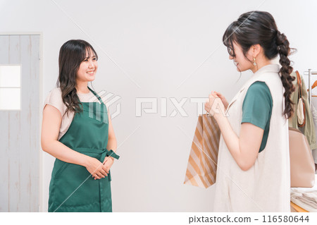 一名女性顧客在服飾店/雜貨店收銀台領取商品 116580644