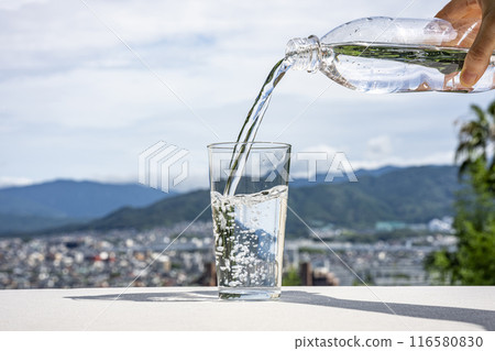 Pouring water from a plastic bottle into a glass Pouring water from a plastic bottle into a glass 116580830