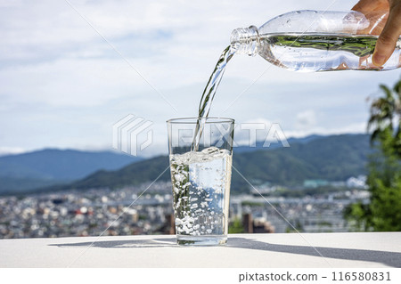 Pouring water from a plastic bottle into a glass Pouring water from a plastic bottle into a glass 116580831