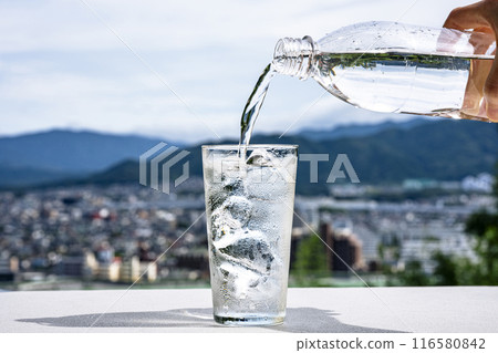 Pouring water from a plastic bottle into a glass Pouring water from a plastic bottle into a glass 116580842