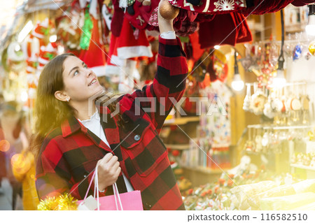Portrait of woman customer near counter with Christmas gifts in evening time Portrait of woman customer near counter with Christmas gifts in evening time 116582510